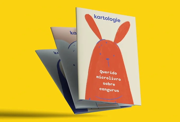 Três microlivros Kartologie empilhados, com destaque para a capa do livro “Querido microlivro sobre cangurus”