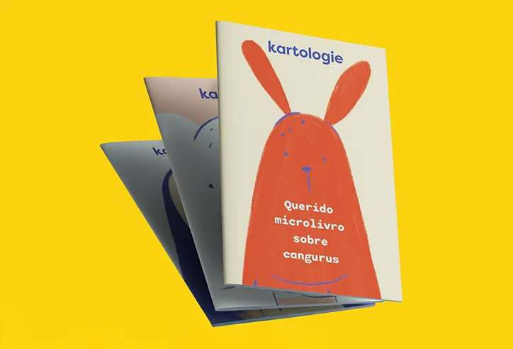 Três microlivros Kartologie empilhados, com destaque para a capa do livro “Querido microlivro sobre cangurus”